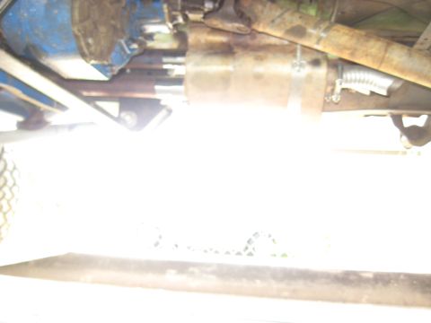 1978 Ford Bronco - A low-angle view of a vehicle's undercarriage, focusing on the exhaust system and transmission parts.