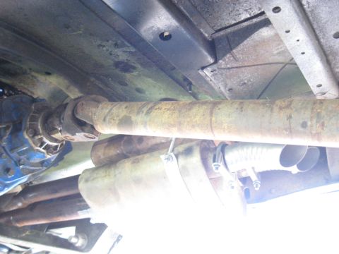 1978 Ford Bronco - Underside of a vehicle, focusing on the drivetrain components and exhaust pipes.