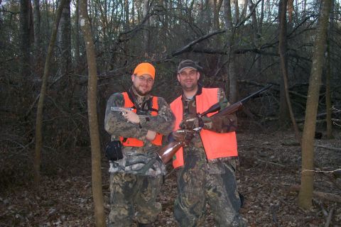 1982 Ford E350 - Hunters pose with their rifles in a forest setting.