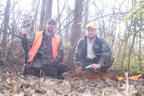 1982 Ford E350 - Hunters display their game after a successful hunt in the woods, with one man holding a rifle and the other a handgun.