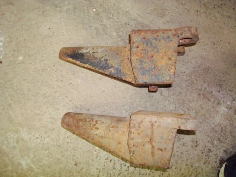1995 Ford Bronco - Two rusty metal parts are shown on a concrete surface. The registry claims they are from a 1995 Ford Bronco, but this is unconfirmed.