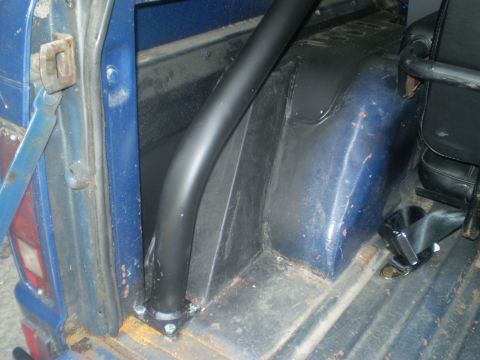1979 Ford Bronco - Close-up view of the interior of a blue vehicle, showing a roll bar and seatbelt.