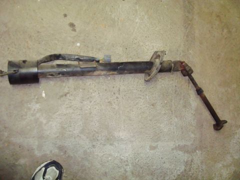 1995 Ford Bronco - A disassembled steering column assembly lies on a concrete floor, showing its internal components.