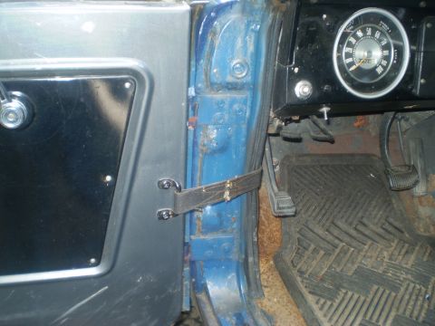 1979 Ford Bronco - Interior view of a blue vehicle showing the door panel, dashboard, and a speedometer.