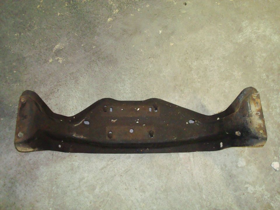 Rusty metal bracket with mounting holes on a concrete surface