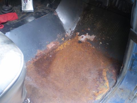 1979 Ford Bronco - The interior floor pan of a vehicle shows extensive rust and corrosion, indicating potential structural issues.