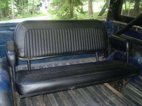 1979 Ford Bronco - Rear bench seat with ribbed vinyl upholstery, seen inside a vehicle's interior.