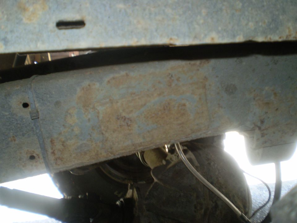 rusted frame section of a vehicle, with some tubing visible