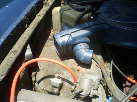 1979 Ford Bronco - Close-up view of an engine bay, showing various hoses and components under blue exterior paint.