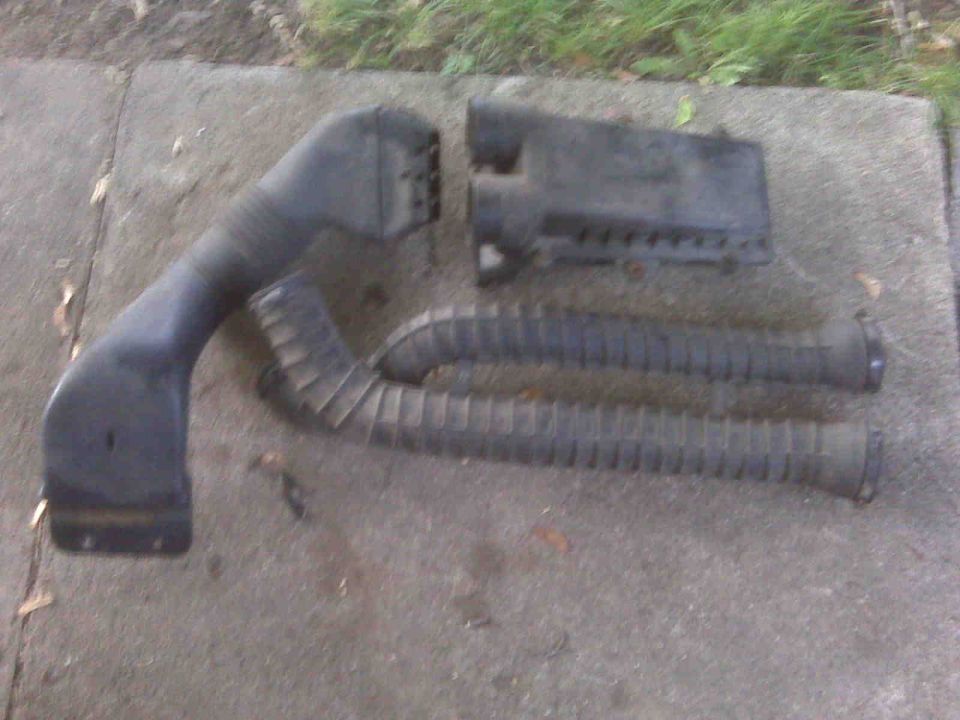 Black plastic air intake hose and filter box on concrete