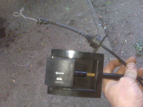 1995 Ford Bronco - Hood release cable and lever mechanism shown close-up.