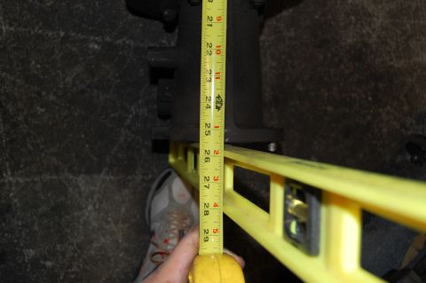 1994 Ford Bronco - A tape measure and level are used to measure a vehicle component.