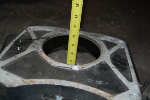 1994 Ford Bronco - Measuring a part with a tape measure; the casting has some handwritten markings.