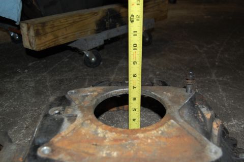1994 Ford Bronco - A yellow measuring tape is placed against a metal component, likely an engine part, to measure its dimensions.