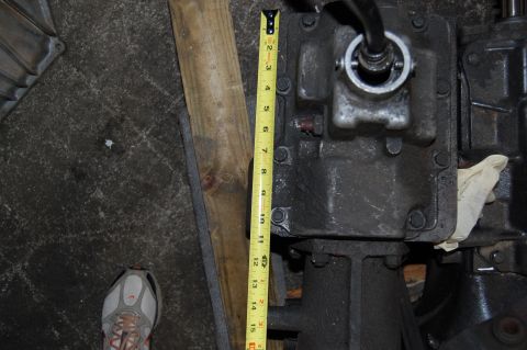 1994 Ford Bronco - Transmission housing measured with a tape measure, shoe visible in background.