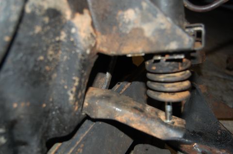 1994 Ford Bronco - This photo shows a close-up view of a vehicle's suspension system, focusing on the spring and associated metal components.