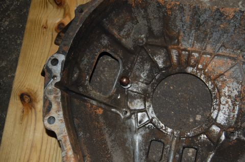 1994 Ford Bronco - Close-up of a heavily rusted transmission bell housing, showing internal casting marks.