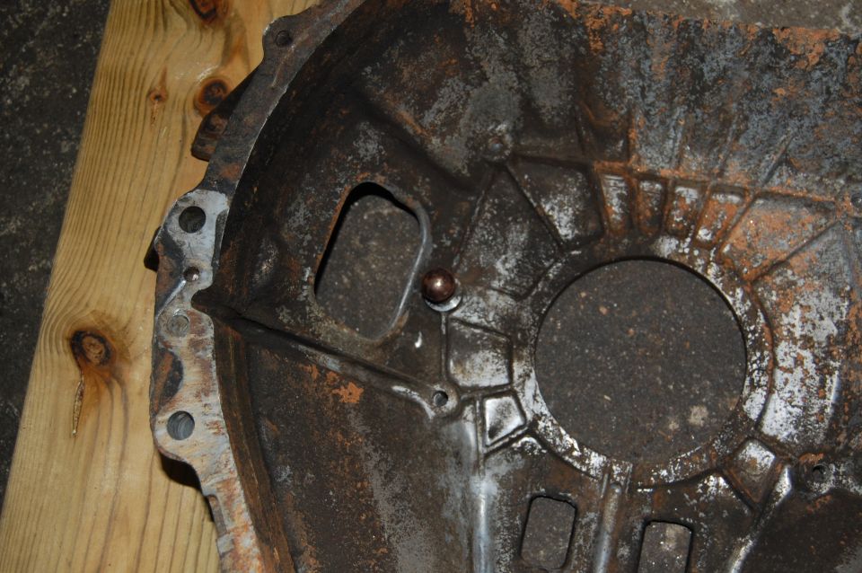 rusted metal transmission bell housing with bolt holes