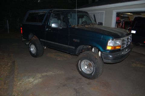 1994 Ford Bronco - Dark green 1994 Ford Bronco with lifted suspension and aftermarket wheels.