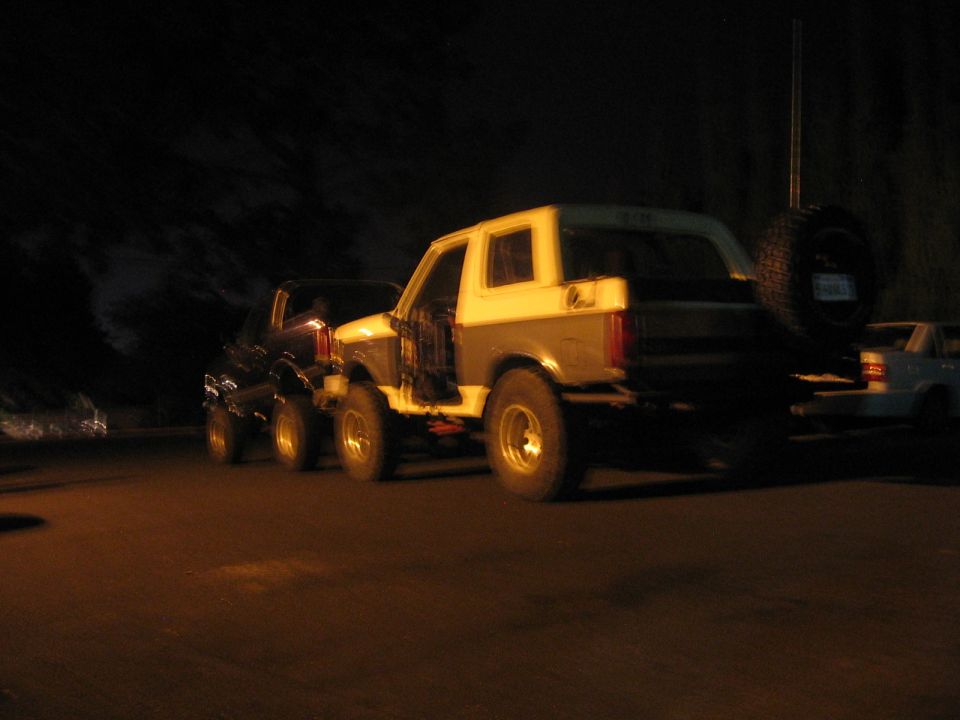 Two-tone SUV with spare tire on back, driver's door open