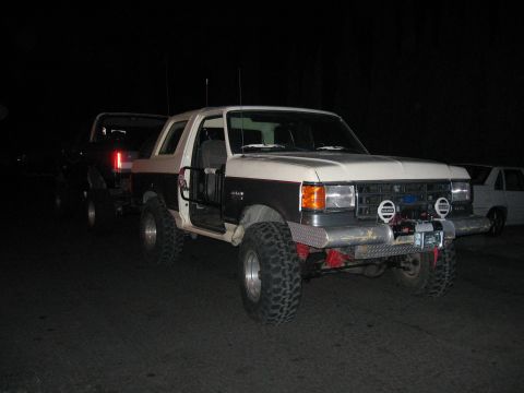 1989 Ford Bronco - Modified 1989 Ford Bronco and another SUV are parked at night, doors open on the Bronco.