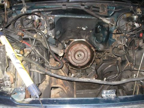 1992 Ford Bronco - Close-up view of a vehicle's engine bay, focusing on the transmission torque converter and surrounding components.