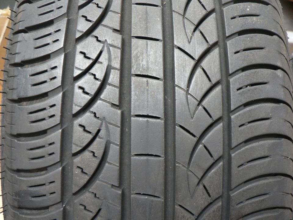 Close-up of a black tire tread with grooves and sipes