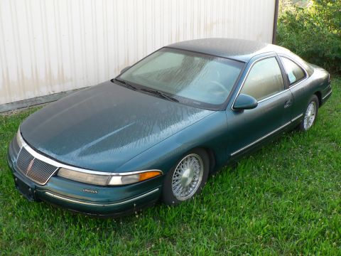1990 Lincoln Mark VII - Green 1990 Lincoln Mark VII coupe with chrome trim parked on grass.