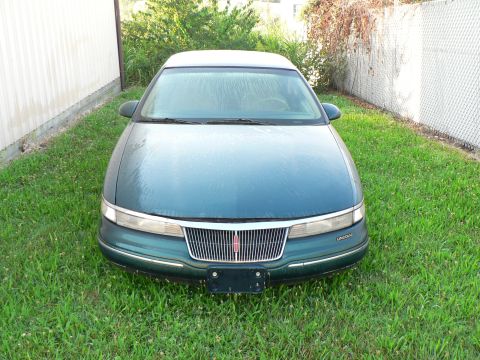 1990 Lincoln Mark VII - This 1990 Lincoln Mark VII is parked on a grassy lawn next to a white wall.