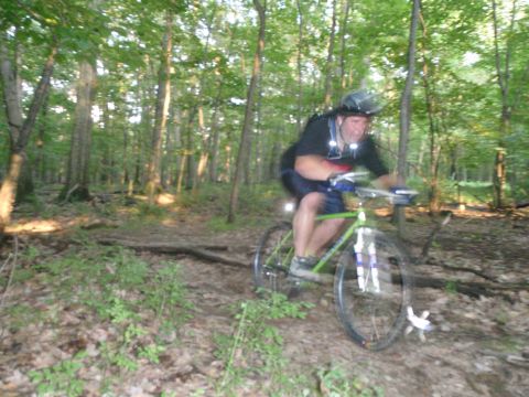 1981 Garelli Rally Sport - A cyclist navigates a wooded trail, sunlight filtering through the trees.