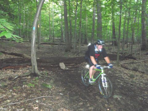 1981 Garelli Rally Sport - A man rides a green mountain bike on a wooded trail.