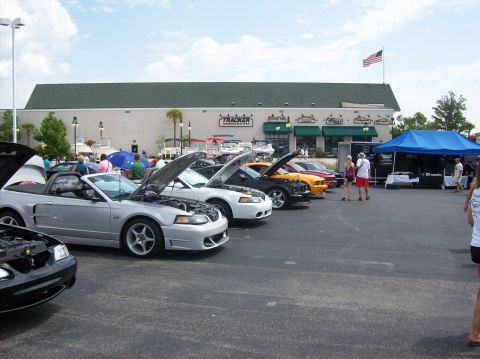 2007 Ford Mustang - Ford Mustangs are displayed with their hoods open at an outdoor car show.