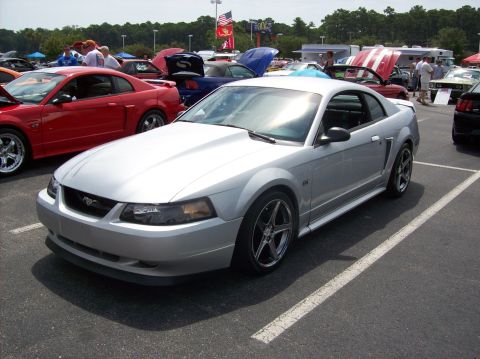 2007 Ford Mustang - A silver Ford Mustang is parked at an outdoor car show with other vehicles around.