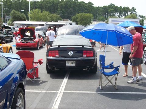 2007 Ford Mustang - Black 2007 Ford Mustang at an outdoor car show, with other cars and people visible.