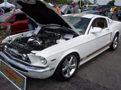 2007 Ford Mustang - A white 1967 Ford Mustang with gold stripes is displayed with its hood open, revealing a modified engine.