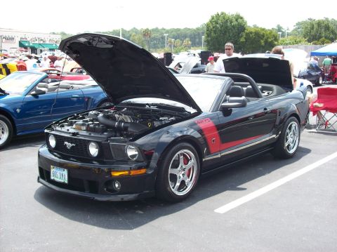 2007 Ford Mustang - A black 2007 Ford Mustang convertible is displayed with its hood open, parked next to a blue Mustang.