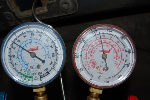 1985 Mercury Grand Marquis - Close-up of two pressure gauges, likely for automotive AC service.