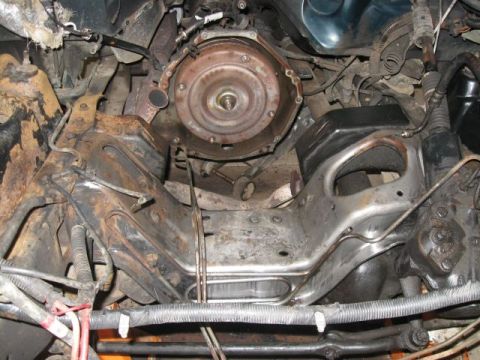 1992 Ford Bronco - Close-up view of a vehicle's transmission and chassis components, showing signs of wear and rust.