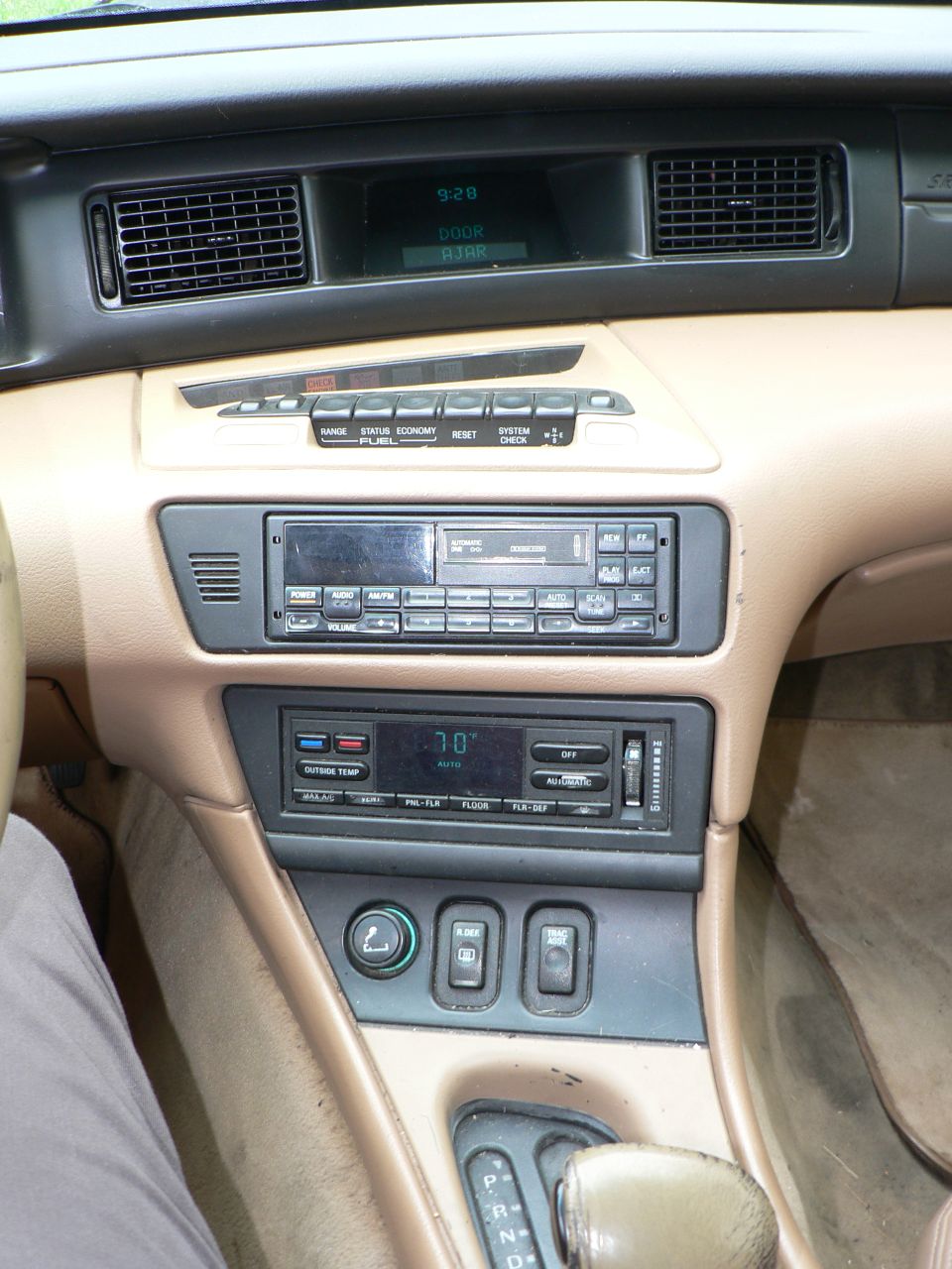 Tan car interior dashboard with digital climate control and radio