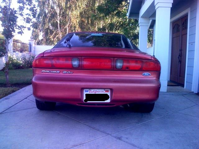 Rear view of a red 1995 Ford Probe parked in a driveway