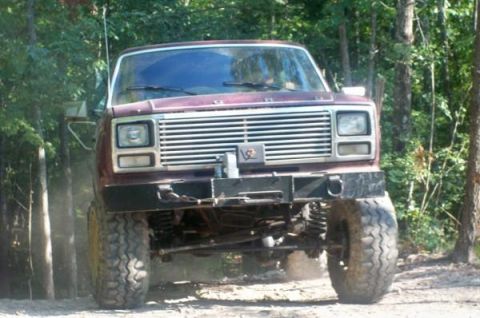 1980 Ford Bronco - This lifted Ford truck is shown from the front, with a prominent grille and off-road tires.