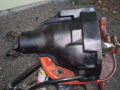 1978 Ford Bronco - A black differential housing with a driveshaft yoke is shown, mounted on an orange bracket.