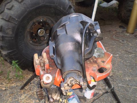 1978 Ford Bronco - A differential housing is clamped in a vise, with a large tire visible in the background.