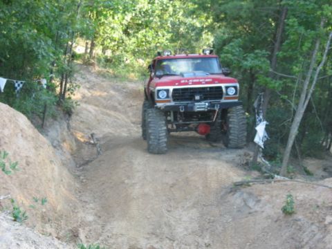 1979 Ford Bronco - This modified 1979 Ford Bronco navigates an off-road trail, its capabilities with oversized tires and a front winch.