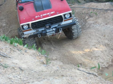 1979 Ford Bronco - This modified 1979 Ford Bronco is navigating a challenging off-road trail with large, aggressive tires.
