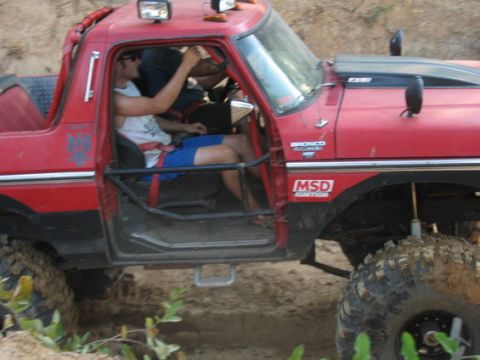 1979 Ford Bronco - This red off-road vehicle has a black hood scoop and an MSD Ignition sticker on the fender.