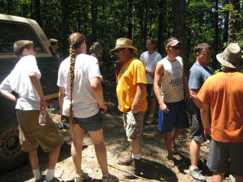 1979 Ford Bronco - A group of people stand around an off-road vehicle in a wooded area on a sunny day.