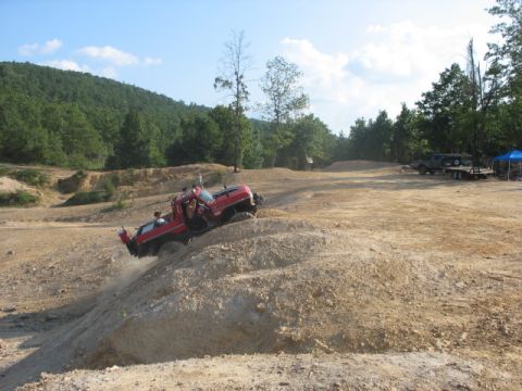 1979 Ford Bronco - A red pickup truck navigates a challenging off-road course, demonstrating its climbing capabilities.