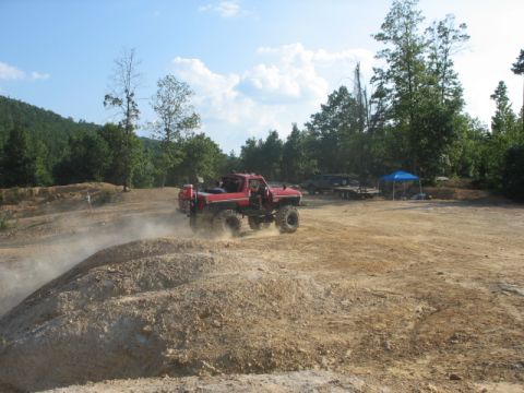 1979 Ford Bronco - Off-road truck navigates a dusty track in a park setting.