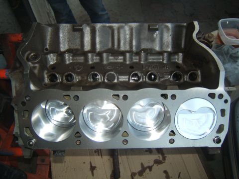 1988 Ford Bronco - A Ford V8 engine block is shown with four pistons installed, ready for further assembly.